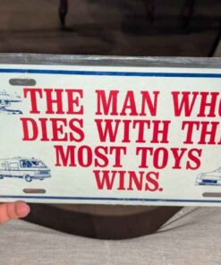 "The Man who dies with the most toys wins" accent plate