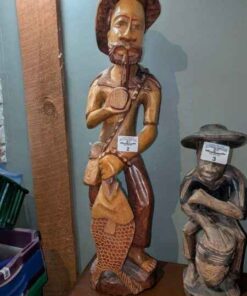 Wooden carving; pipe smoker holding a fish