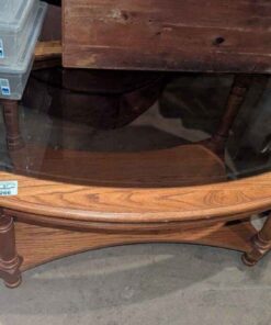 Oval Glass topped wooden coffee table with bottom shelf