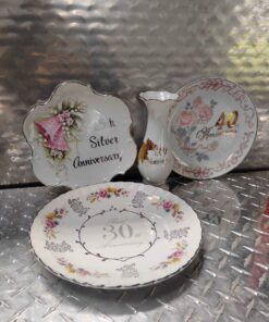 Assortment of anniversary plates and vase