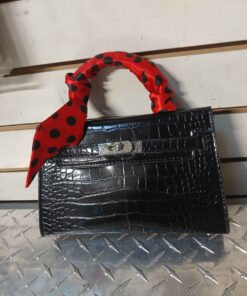 Black purse with red and black polka dot strap