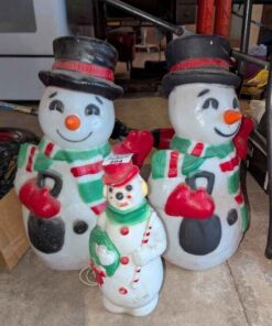 Trio of illuminated plastic snowmen lawn figures