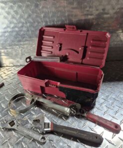 Red tool box with oil filter wrench adjustables and more