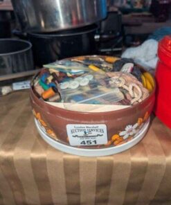 Yarn, buttons, thread in covered tin
